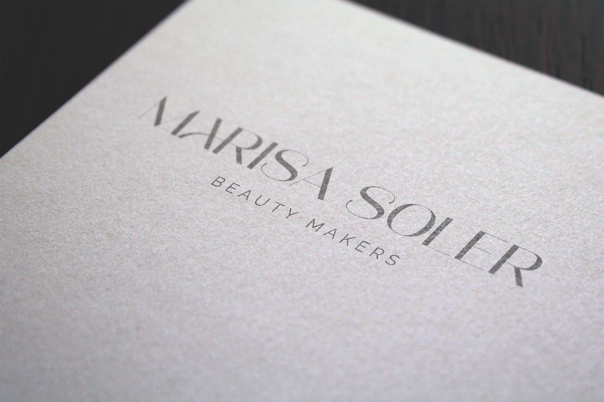 Logotipo Marisa Soler grabado en papel texturizado